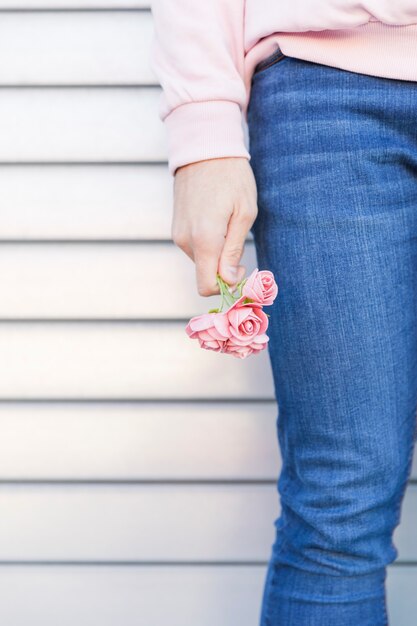 Mann, der schöne rosafarbene Blumen anhält