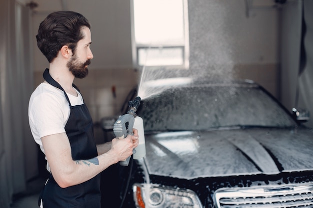 Mann, der sein Auto in einer Garage wäscht