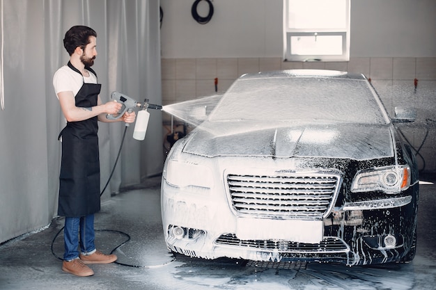 Mann, der sein Auto in einer Garage wäscht