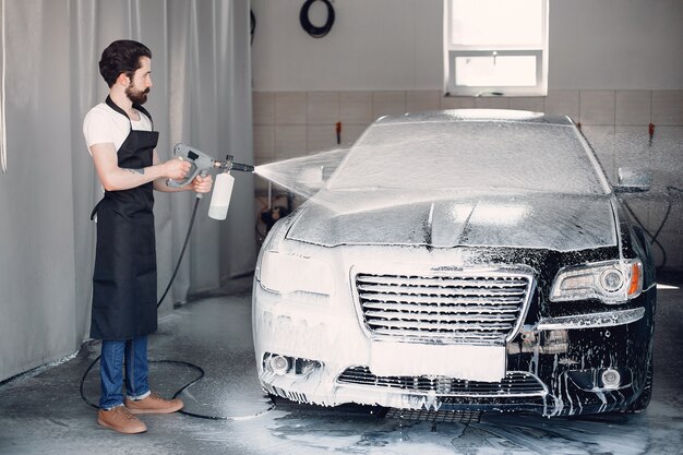 Mann, der sein Auto in einer Garage wäscht