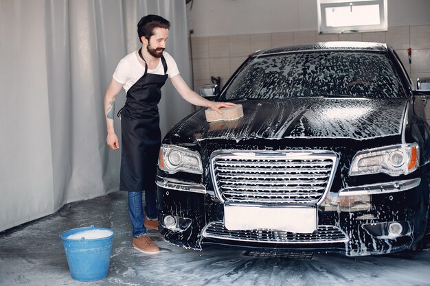 Mann, der sein Auto in einer Garage wäscht