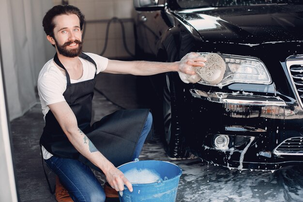 Mann, der sein Auto in einer Garage wäscht