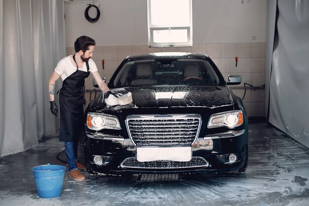 Mann, der sein Auto in einer Garage wäscht