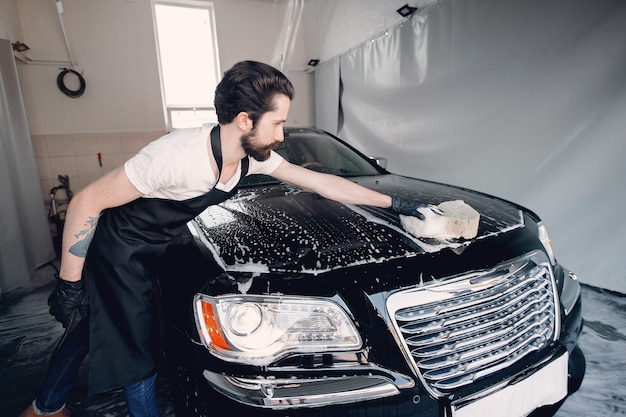 Mann, der sein Auto in einer Garage wäscht