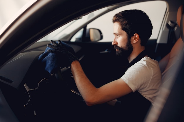 Mann, der sein Auto in einer Garage wäscht