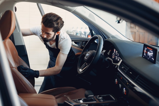 Kostenloses Foto mann, der sein auto in einer garage wäscht