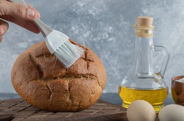 Mann, der sein Roggenbrot mit Öl bedeckt. Hochwertiges Foto