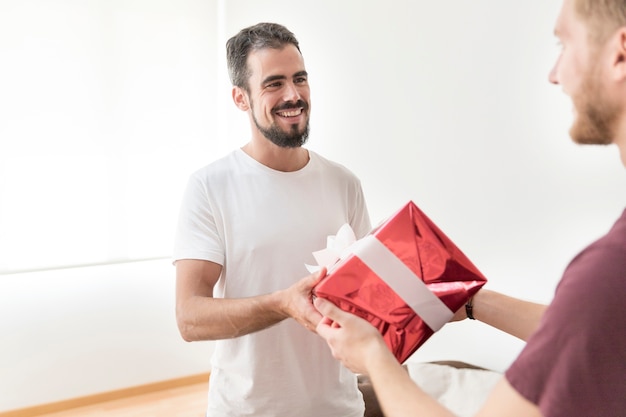 Kostenloses Foto mann, der seinem freund geburtstagsgeschenk gibt