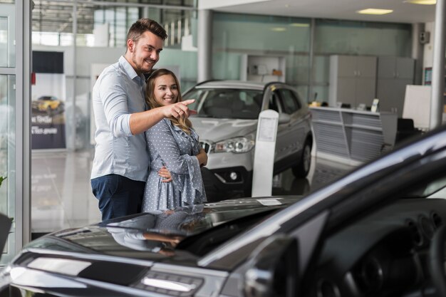 Mann, der seiner Freundin ein Auto zeigt