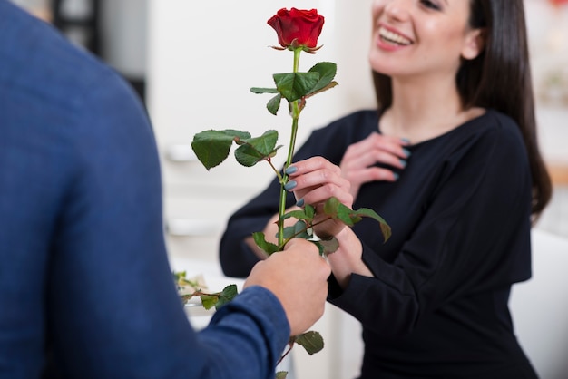 Mann, der seiner Freundin eine Rose zum Valentinstag anbietet