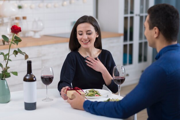 Mann, der seiner Smiley-Freundin ein Geschenk zum Valentinstag gibt