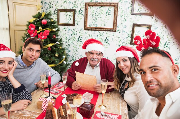 Mann, der selfie mit Familie am festlichen Tisch nimmt