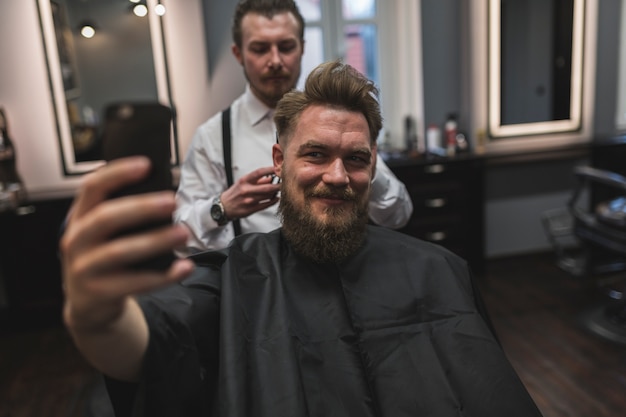 Mann, der selfie mit Friseur nimmt