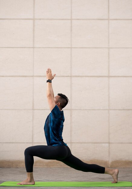 Mann, der sich draußen beim Yoga ausdehnt