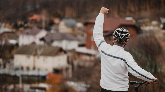 Mann, der siegreich ist, nachdem er sein Fahrrad mit Kopienraum gefahren ist