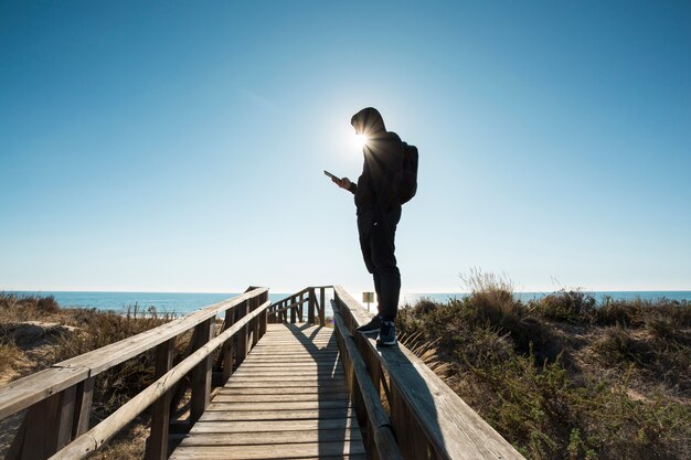 Mann, der Smartphone auf Geländern verwendet