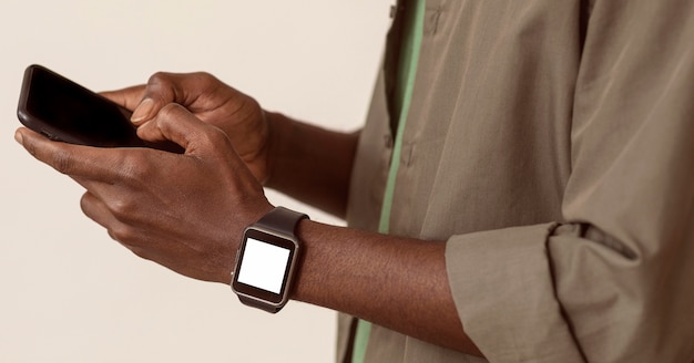 Mann, der Smartphone benutzt und intelligente Uhr trägt