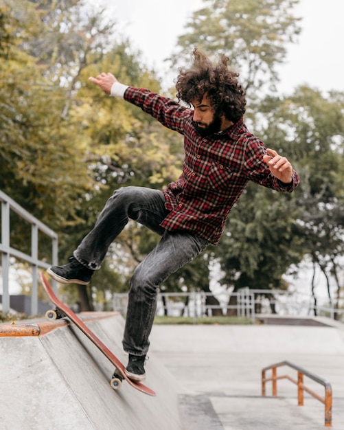 Mann, der Spaß mit Skateboard im Stadtpark hat