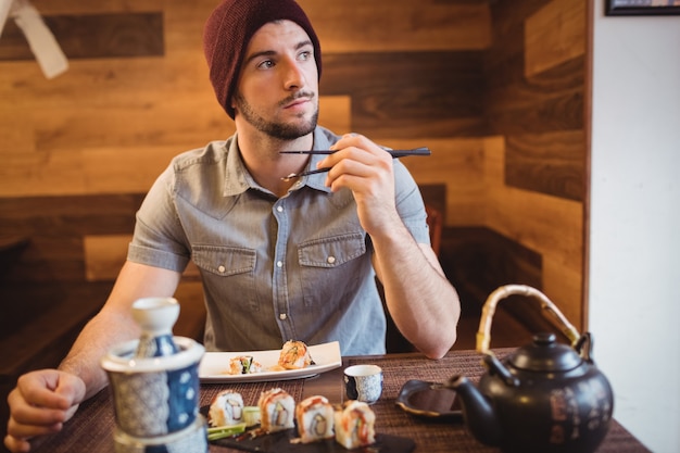 Mann, der Sushi im Restaurant isst