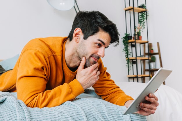 Mann, der Tablette und das Denken verwendet