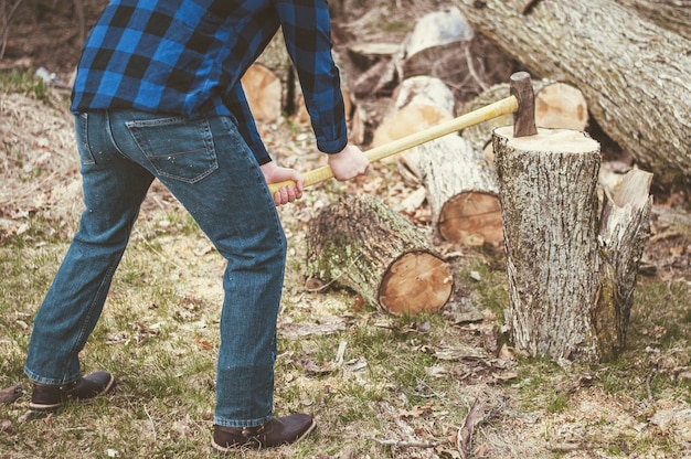 Mann, der tagsüber mit einer Axt Holz schneidet