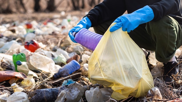 Kostenloses Foto mann, der verstreute plastikflaschen vom boden sammelt