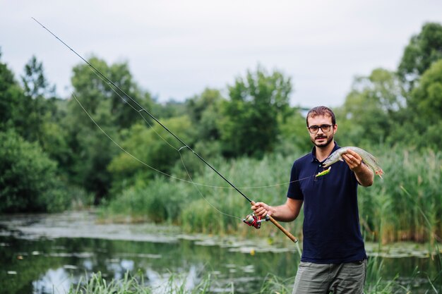 Mann, der vor der Seeholding gefangenen frischen Fischen steht