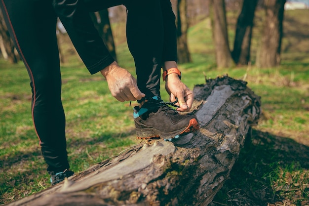 Mann, der vorbereitet, in einem Park oder Wald gegen Baumraum zu laufen