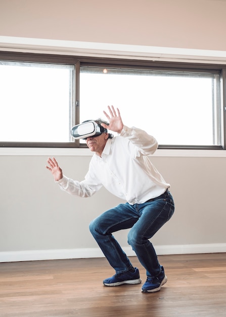 Mann, der vortäuscht zu berühren, während er Kopfhörer der virtuellen Realität trägt