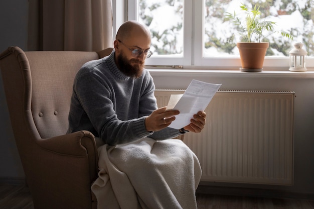 Kostenloses Foto mann, der während der energiekrise auf die rechnung schaut