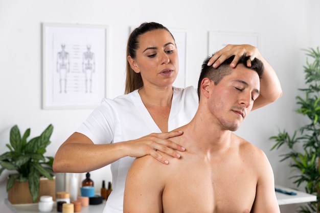 Kostenloses Foto mann, der während der physiotherapie-sitzung eine massage erhält