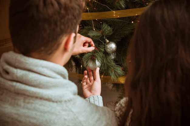 Mann, der Weihnachtsbaum mit Ball verziert