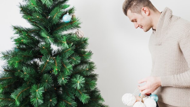 Mann, der Weihnachtsbaum verziert