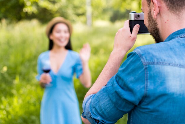 Mann, der wellenartig bewegende Frau in der Landschaft fotografiert