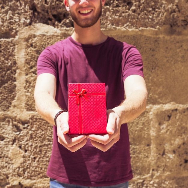 Mann, der wieder rote geschenkboxwand hält