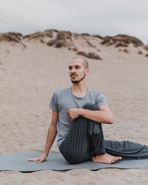 Mann, der Yoga im Freien ausübt