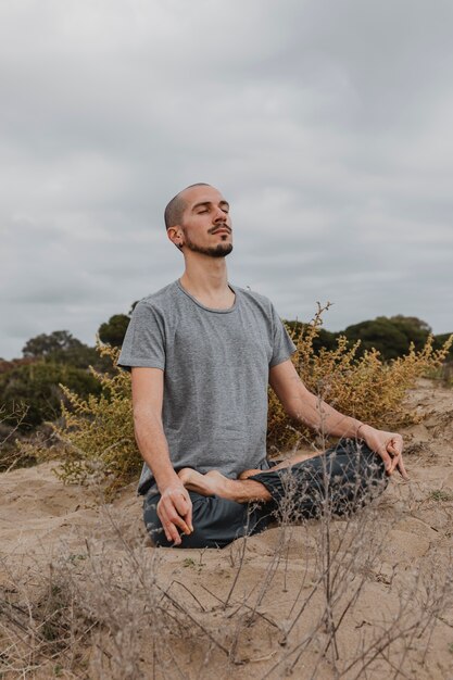 Mann, der Yoga im Freien praktiziert