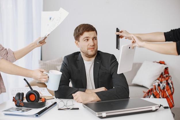 Mann, der zu Hause im Wohnzimmer sitzt. Trauriger Mann müde von der Arbeit.