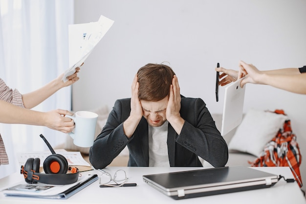 Mann, der zu Hause im Wohnzimmer sitzt. Trauriger Mann müde von der Arbeit.