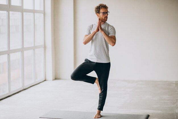 Mann, der zu Hause Yoga auf der Matte praktiziert