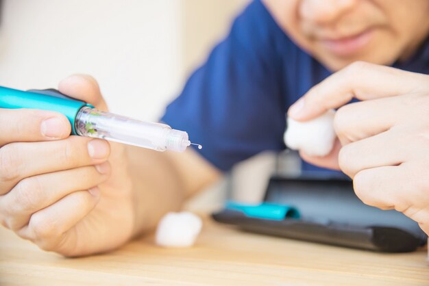 Mann, der zuckerkranke Spritze des Insulins für Einspritzung vorbereitet
