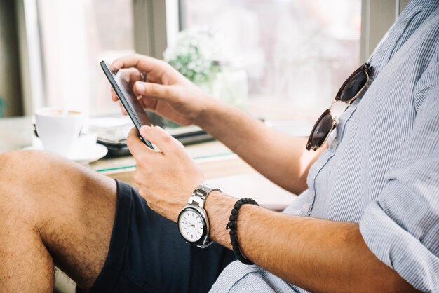 Mann des Gesichtslosen Mannes, der Telefon im Café durchstöbert