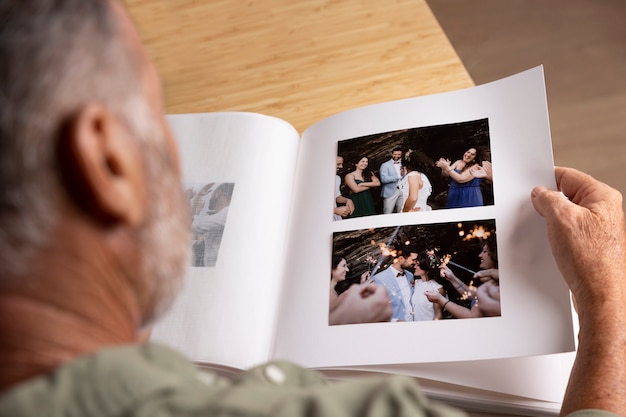 Mann des hohen Winkels, der Fotoalbum betrachtet