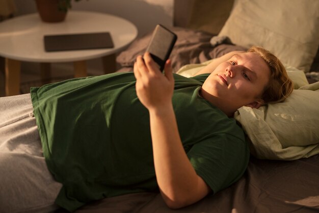 Mann des hohen winkels, der smartphone hält