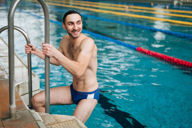 Mann des hohen Winkels, der vom Swimmingpool erlischt