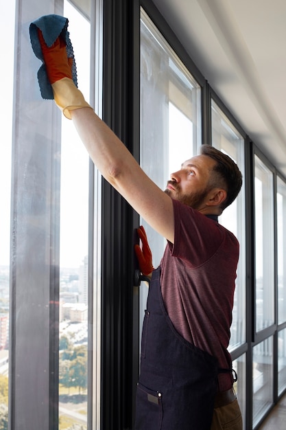 Kostenloses Foto mann-diener, der fenster wäscht