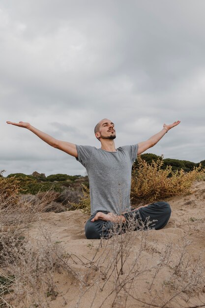 Mann draußen, der Yoga macht