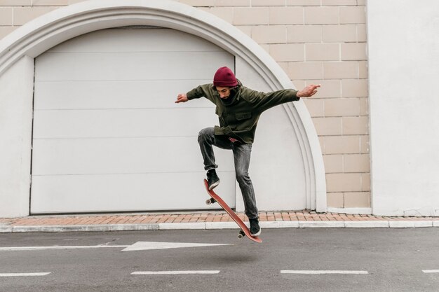 Mann draußen mit Skateboard in der Stadt