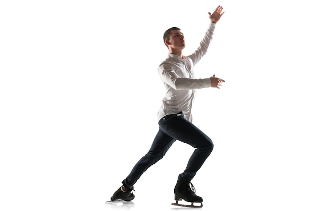 Mann Eiskunstlauf isoliert auf weißer Studiowand mit Exemplar. Professionelles Üben und Trainieren in Aktion und Bewegung auf dem Eis. Anmutig und schwerelos. Konzept der Bewegung, Sport, Schönheit.