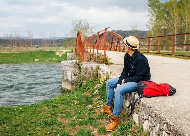 Mann entspannen sich, Bank von flüssigem Fluss stationierend